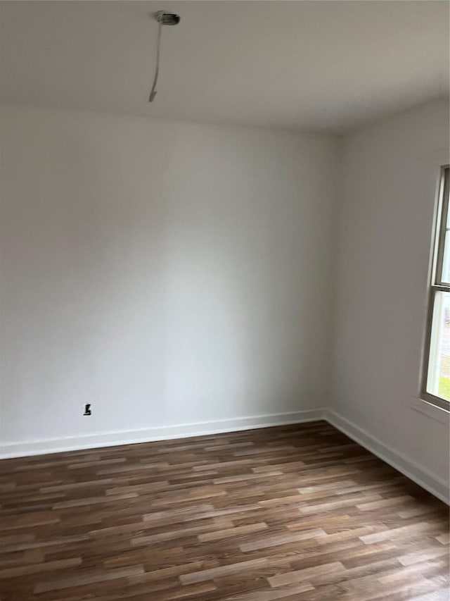 empty room with dark hardwood / wood-style flooring