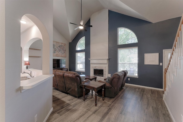 living room with ceiling fan, wood-type flooring, high vaulted ceiling, and a healthy amount of sunlight