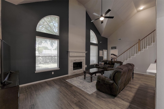 living room featuring a high ceiling, ceiling fan, and dark hardwood / wood-style flooring