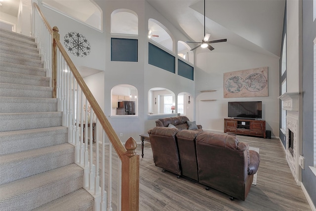 living room with ceiling fan, a high ceiling, and hardwood / wood-style flooring