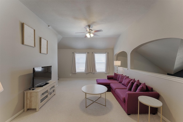 carpeted living room with vaulted ceiling, ceiling fan, and a textured ceiling