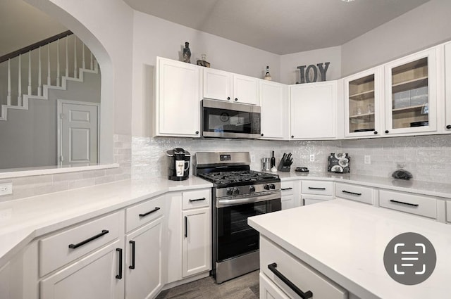 kitchen featuring light hardwood / wood-style floors, white cabinetry, stainless steel appliances, and tasteful backsplash