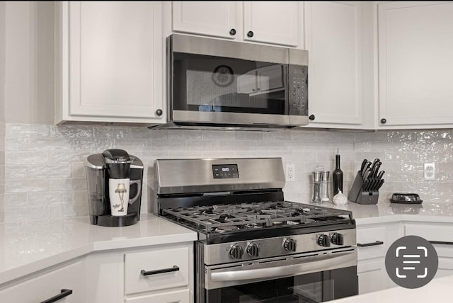 kitchen featuring white cabinets, stainless steel appliances, and tasteful backsplash