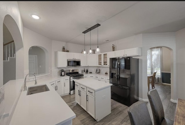 kitchen featuring sink, a center island, appliances with stainless steel finishes, and white cabinetry