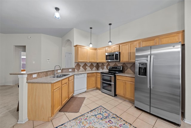 kitchen with backsplash, sink, decorative light fixtures, kitchen peninsula, and stainless steel appliances