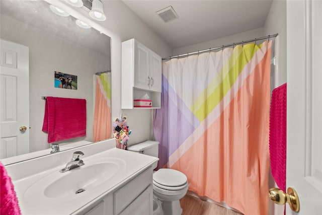 bathroom with vanity, wood-type flooring, and toilet