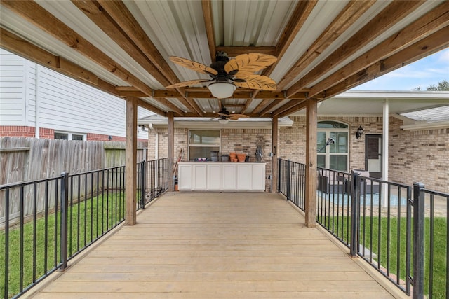 wooden terrace with a lawn and ceiling fan