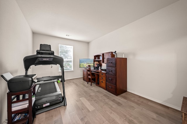 exercise room with light wood-type flooring