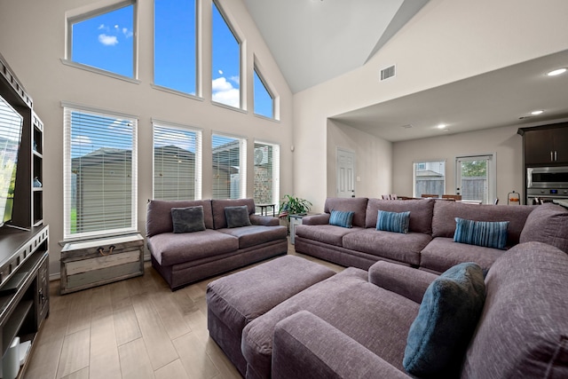 living room with a high ceiling and light hardwood / wood-style floors