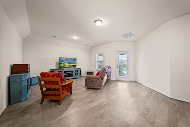 living room featuring light hardwood / wood-style flooring and vaulted ceiling