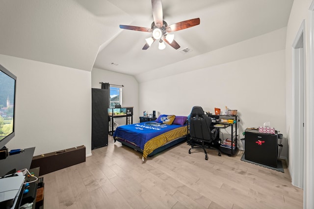 bedroom with light wood-type flooring, vaulted ceiling, and ceiling fan