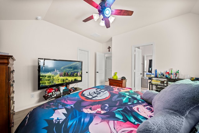 bedroom featuring ceiling fan, hardwood / wood-style floors, ensuite bathroom, and lofted ceiling