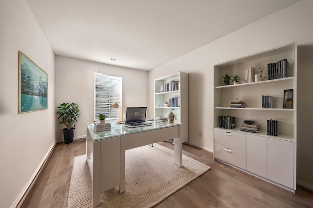 office area featuring visible vents, light wood-style flooring, and baseboards