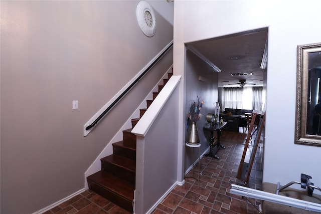 stairs featuring ceiling fan