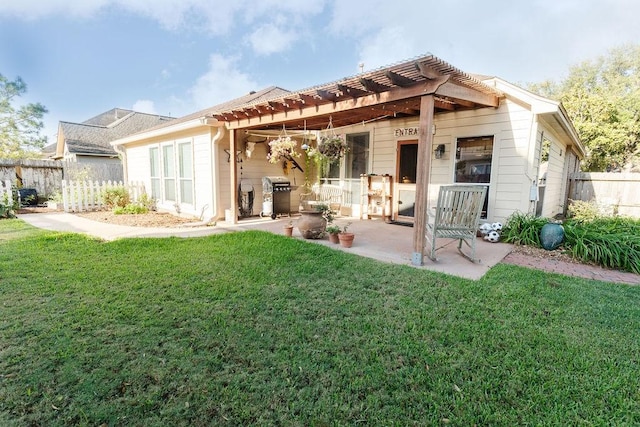 rear view of house featuring a pergola, a patio area, and a lawn