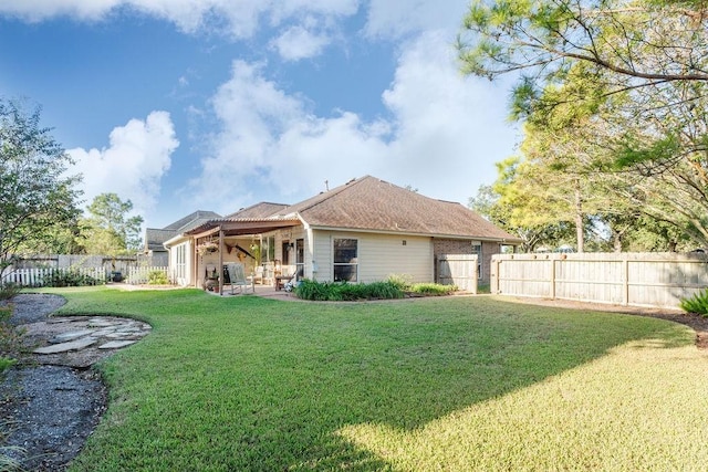 rear view of house featuring a yard