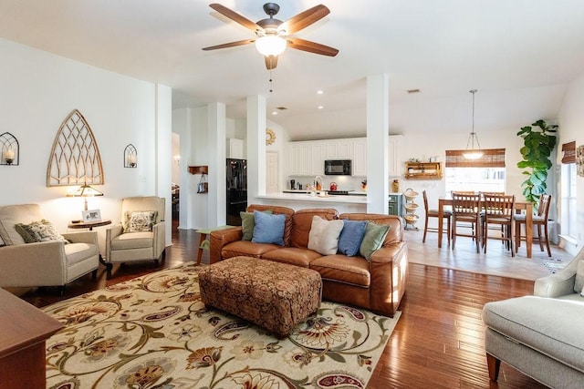 living room featuring ceiling fan, wood-type flooring, and sink