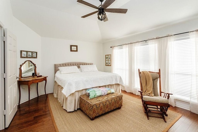 bedroom featuring ceiling fan, vaulted ceiling, wood-type flooring, and multiple windows