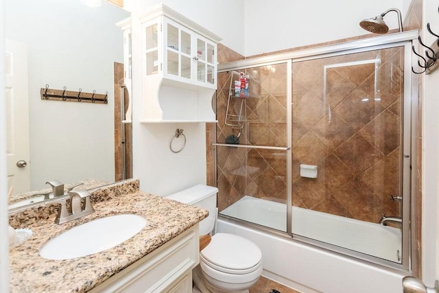 full bathroom featuring toilet, vanity, and combined bath / shower with glass door