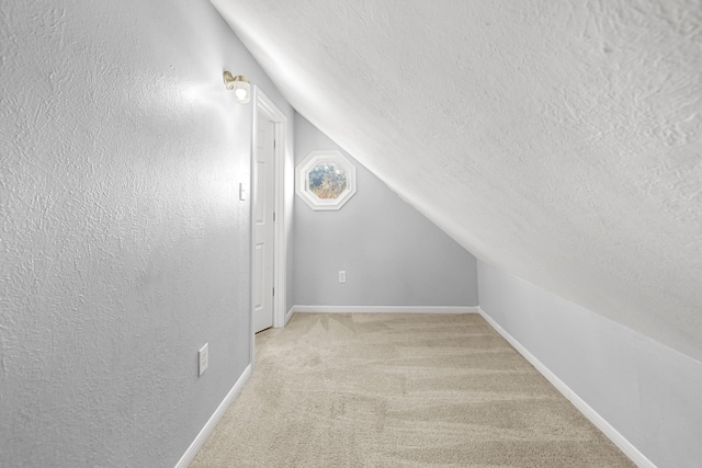 bonus room featuring light carpet, a textured ceiling, and lofted ceiling