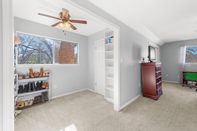 interior space with ceiling fan, lofted ceiling, and light carpet