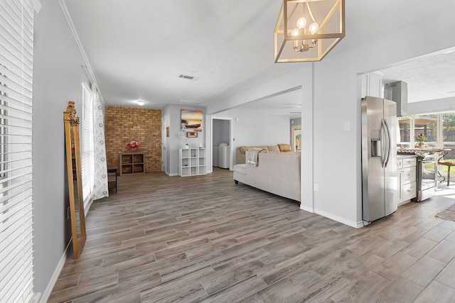 corridor with wood-type flooring and an inviting chandelier