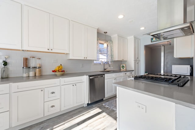 kitchen with white cabinetry, sink, hanging light fixtures, light hardwood / wood-style floors, and appliances with stainless steel finishes