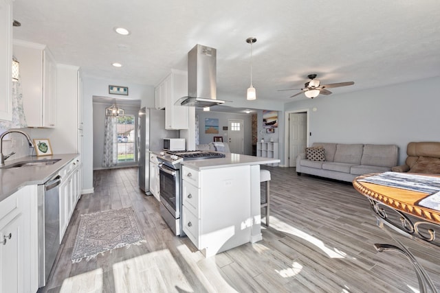 kitchen with wall chimney exhaust hood, sink, white cabinetry, and stainless steel appliances