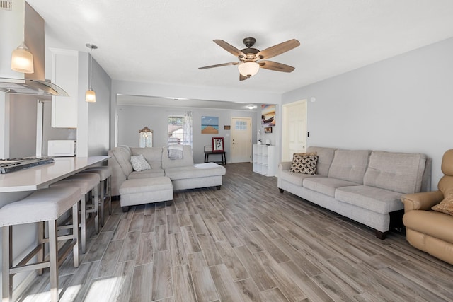 living room featuring ceiling fan and hardwood / wood-style floors