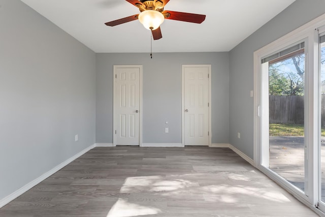 unfurnished bedroom with access to outside and ceiling fan