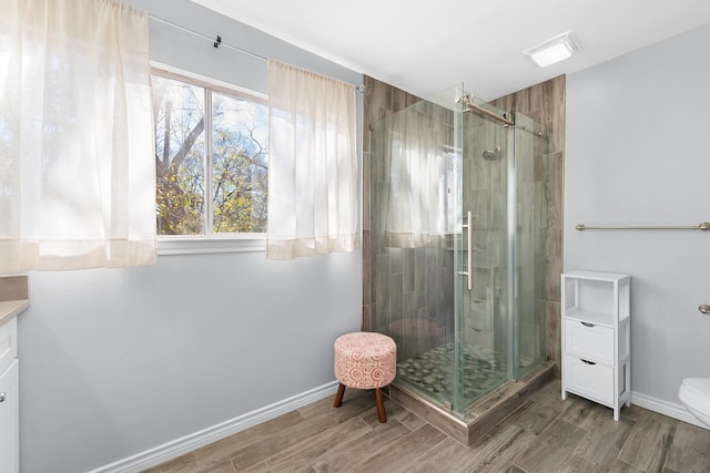 bathroom with hardwood / wood-style floors, vanity, and walk in shower