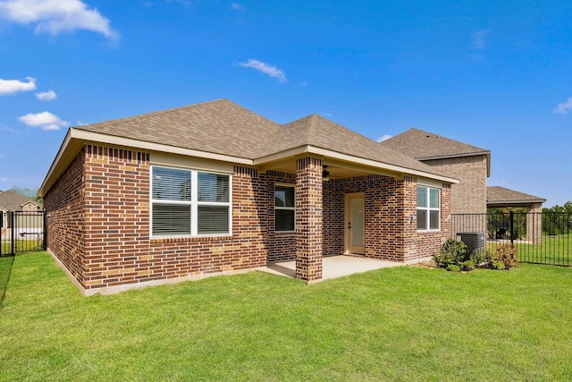 back of house with a patio and a lawn