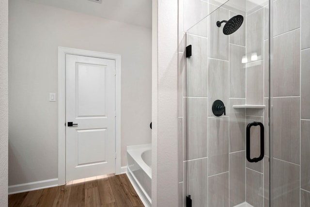 bathroom featuring hardwood / wood-style floors and separate shower and tub