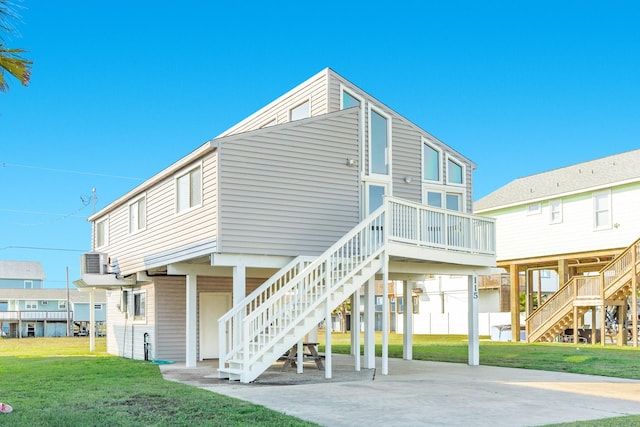 rear view of property with a lawn, cooling unit, and a carport