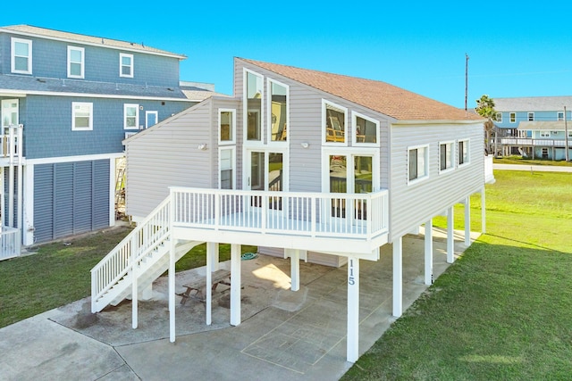 rear view of property featuring a deck, a yard, a carport, a patio area, and stairs