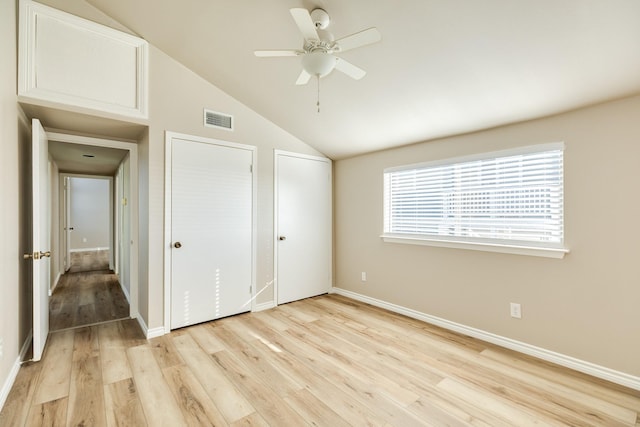 unfurnished bedroom with ceiling fan, light wood-type flooring, and vaulted ceiling