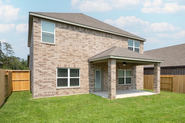 rear view of property with a lawn, ceiling fan, and a patio area