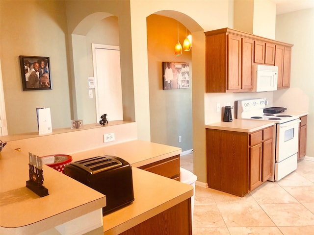 kitchen featuring kitchen peninsula, light tile patterned floors, decorative light fixtures, and white appliances