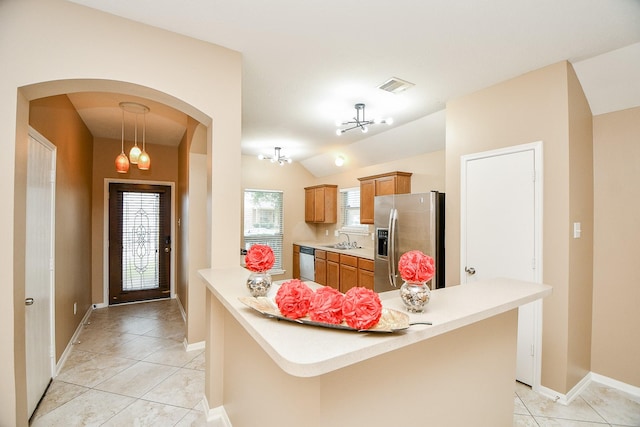 kitchen featuring sink, appliances with stainless steel finishes, light tile patterned flooring, vaulted ceiling, and a chandelier