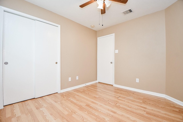 unfurnished bedroom featuring ceiling fan, a closet, and light hardwood / wood-style flooring