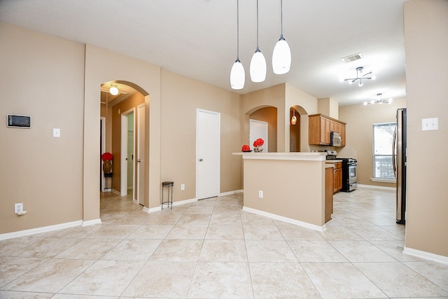 kitchen with hanging light fixtures, light tile patterned floors, and stainless steel appliances