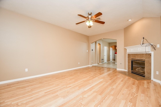 unfurnished living room featuring ceiling fan, a fireplace, and light hardwood / wood-style flooring