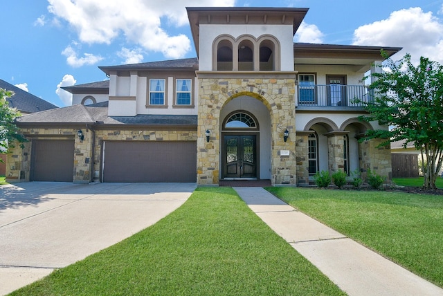 view of front of house with a balcony, a front lawn, french doors, and a garage