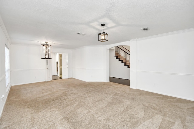 carpeted spare room with a textured ceiling and ornamental molding