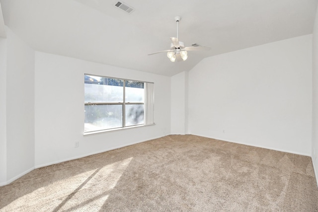 carpeted spare room featuring ceiling fan and vaulted ceiling