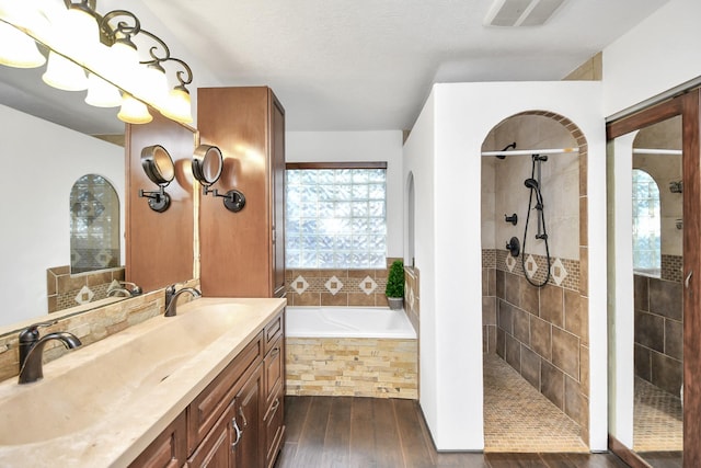 bathroom featuring vanity, a wealth of natural light, plus walk in shower, and wood-type flooring