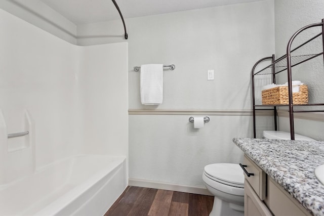 full bathroom with washtub / shower combination, toilet, vanity, and hardwood / wood-style flooring