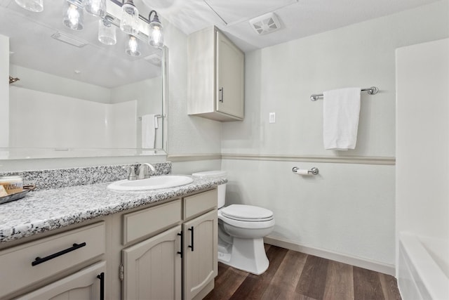 bathroom with toilet, vanity, and hardwood / wood-style flooring