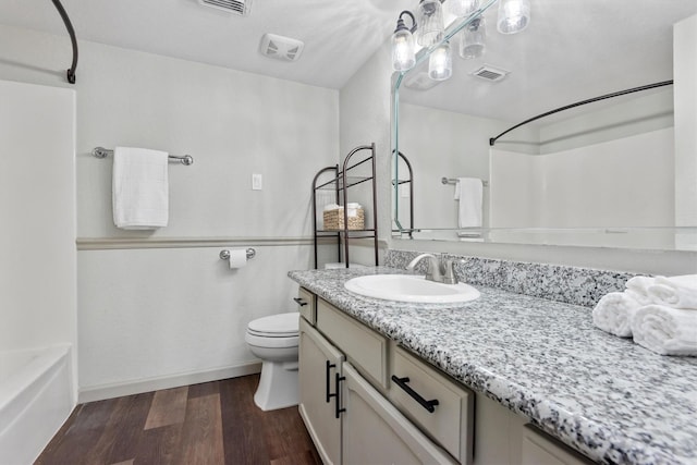 full bathroom with hardwood / wood-style flooring, vanity, toilet, and tub / shower combination