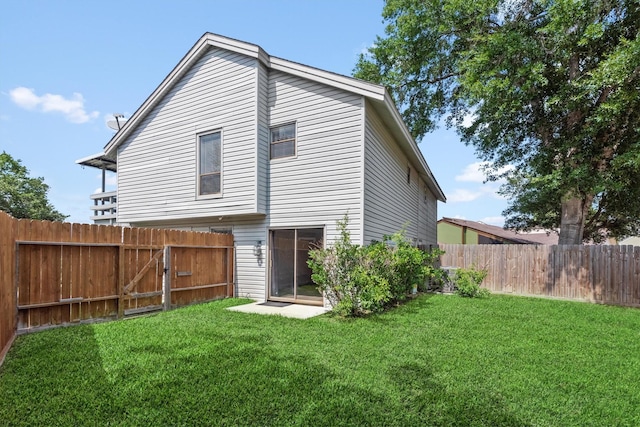 back of house featuring a lawn